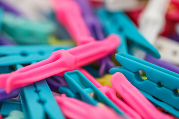 Bundle of bright multi colored clothes pegs close up