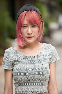 Young Beautiful Asian Woman With Pink Hair Outdoors