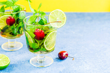 Non-alcoholic cold mojito in two glass glasses. Lemonade with lime and mint on a light background. Copy space.