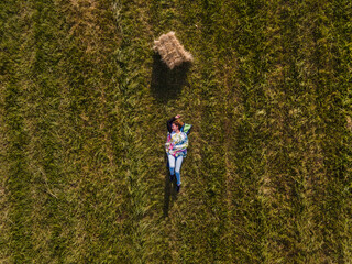 Top down aerial view on young adult caucasian woman lying alone in the field - Drone image on beautiful girl relaxing in nature - freedom travel carefree solitude concept