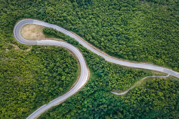Aerial top down view drone image of curvy mountain road asphalt with serpentine trough trees green forest in day summer taken in Serbia Tresibaba Knjazevac Balkans - nature travel concept