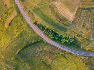 Aerial view top down from above on the country road in mountain range in between green grass and trees around - nature travel concept drone photo on Tresibaba in Europe Serbia in sunny summer day