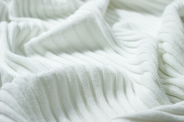 Background from natural textile. Very soft knitted cotton of white color with stripes and folds. The surface of cotton corrugated blanket for baby borns or warming in cold weather. 