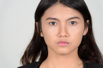 Portrait of young beautiful Asian woman looking at camera