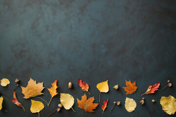 Hello autumn. Template made of dried leaves and acorns on dark background. Seasonal background, fall concept, thanksgiving day composition. Flat lay, copy space