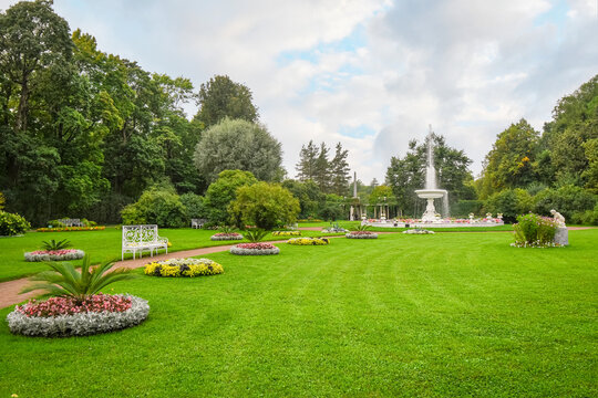 A peaceful garden with flowers, water fountain and bench near Catherine's Garden and Palace at Pushkin, Saint Petersburg, Russia.