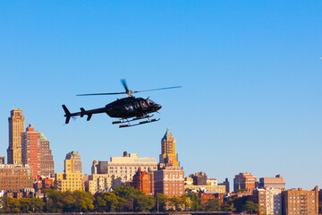 Black helicopter flies against the background of Brooklyn in the city of New York, USA