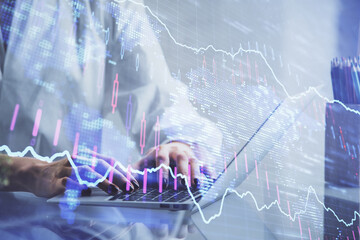 Double exposure of woman hands typing on computer and forex chart hologram drawing. Stock market invest concept.