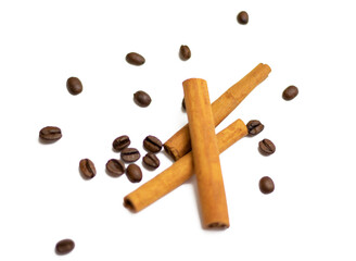 Cinnamon spice and coffee beans scattered over a white background