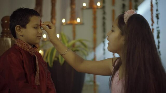  sister tying rakhi, Raksha bandhan to brother's wrist during festival or ceremony - Raksha Bandhan celebrated across India as selfless love or relationship between brother and sister