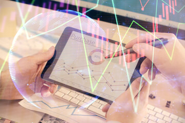 Double exposure of man's hands holding and using a phone and financial chart drawing. Market analysis concept.