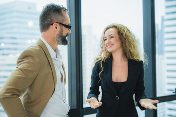 Discussion of business partner, young women and man discussing about the project in the office.