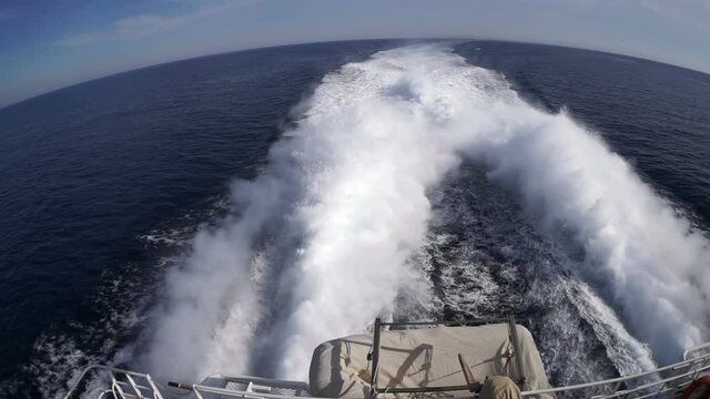 Marmaris. Turkey. May 25, 2019; Water trail from the boat engine. Waves and a lot of foam diverge from a powerful engine. Curved lightning horizon. Fish eye.