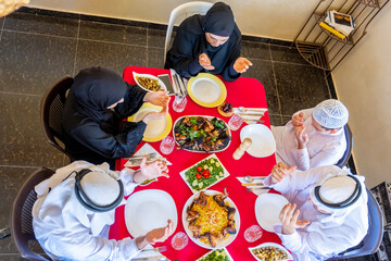 Happy arabic muslim family praying to god prior eating and askin