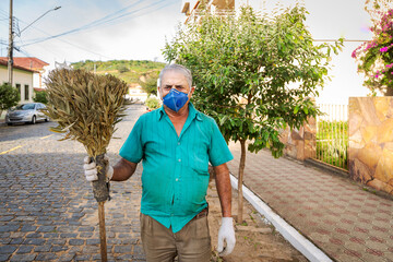 Varredor de rua trabalha com máscara de proteção contra coronavirus em Guarani, Minas Gerais,...