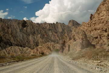 Adventure. The arid desert. Driving along the dusty dirt road across the rocky valley and sandstone hills. 