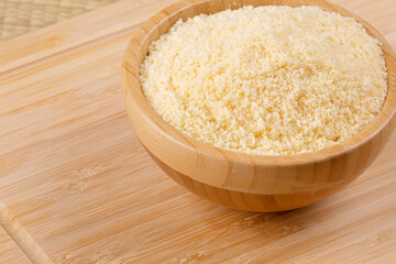 Wooden bowls of Grated Parmesan Cheese on a wooden background