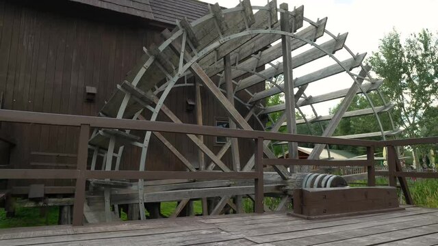 Still view of massive wooden wheel of vintage watermill.
