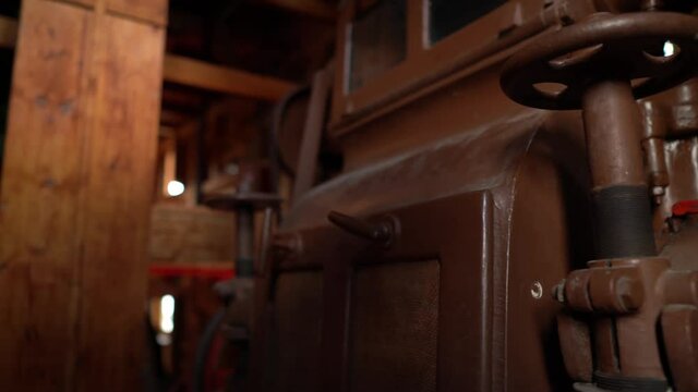 Panning view of big old steel valve in an old watermill.