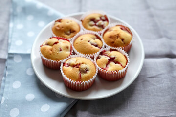 Strawberry muffins with fresh berries on white plate on linen napkin background