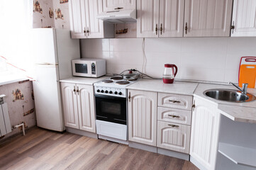 Interior beige small cozy kitchen, cabinets, electric stove