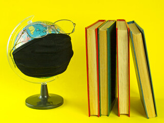 concept of education during the coronavirus pandemic. social distance and new school year. globus wearing protective medical mask.