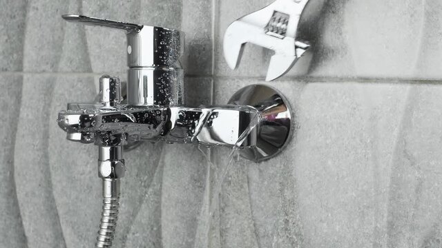 Plumber Fixing a water leaking tap Faucet by Adjustable wrench