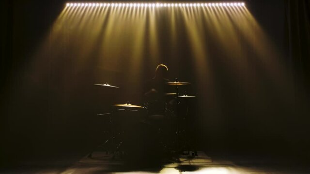 Classic retro chrome microphone and electric guitar together with drums and piano synthesizer keyboard on the stage in dark studio with smoke and neon lighting. Dynamic blue neon lighting effects