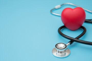 Heart shaped squeeze ball for hand muscle exercise and stethoscope  on blue background and copy space