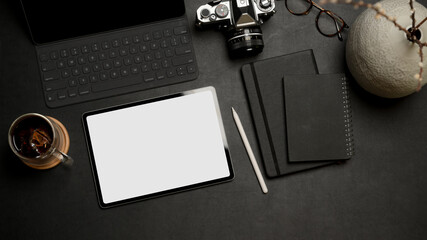 Digital tablet with clipping path on dark office desk with office supplies