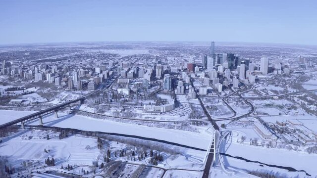 Aerial panout from downtown Edmonton capital city on a stunning beautiful winter day clear sky blue gradaitions snow covered North Saskatchewan River Walter Dale Bridge high level bridge panaramic
