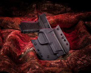9mm pistol in holster on fur background with red studio lighting.