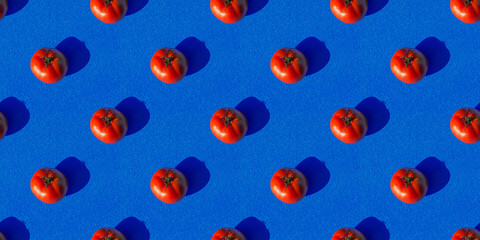 Seamless texture. Pattern of red tomatoes on a dark blue background.