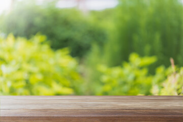 Empty wood table top and blurred green tree and vegetable in agricultural farms. background - can...