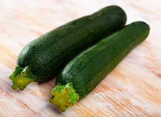 Image of raw green zucchini on wooden surface in kitchen
