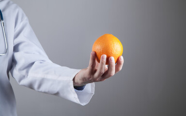 Caucasian doctor showing orange.