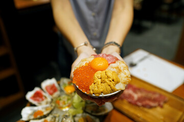 Mini donburi bowl - Japanese rice bowl topped with fresh tuna, sea urchin roe, salmon roe, scallop, sweet shrimp and topping egg yolk.