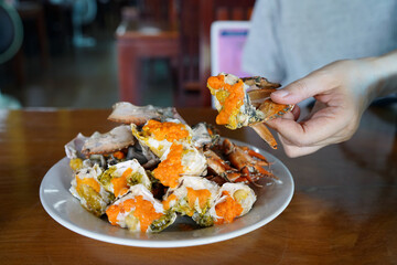 Boiled crab with milk - A plate of steamed black crab with crab's spawn (roe) and claw.