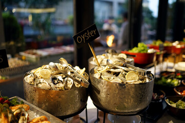 Fresh opened oyster on ice bucket, Seafood buffet line in Restaurant, Delicious International Food.