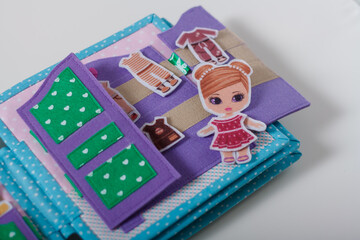 Educational felt book with small wooly details and buttons for little children. Girl, wardrobe for clothing. Leisure and early preschool development, distant home education concept.