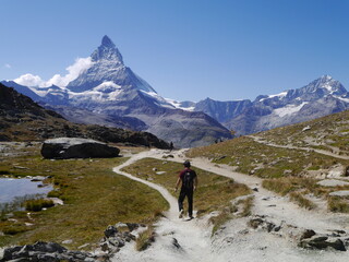 Fototapeta premium Tourists riding a bicycle on an adventure tour of the beautiful nature hiking trails of Matterhorn mountains, a nature attraction in Switzerland, August 15, 2015.