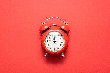 Red alarm clock on the red background top view.