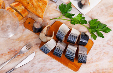 Salted mackerel on wooden board with baguette. High quality photo