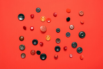 Red clothing buttons on the red flat lay background.