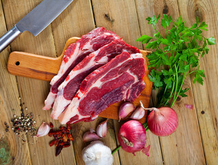 Fresh raw meat, sliced boneless beef steak on wooden background