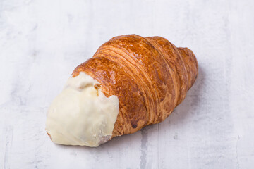 croissant with cream filling on a light background