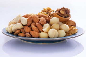 Nutritious mixed nuts on the plate, walnuts, almonds, cashews, macadamia nuts