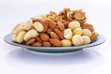 Fototapeta na wymiar Nutritious mixed nuts on the plate, walnuts, almonds, cashews, macadamia nuts
