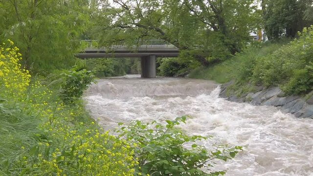 Sidewise movement over a muddy highwater river with a bridge in slow motion