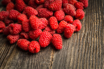 Freshly harvested raspberry on the rustic wooden background. Selective focus. Shallow depth of field.
